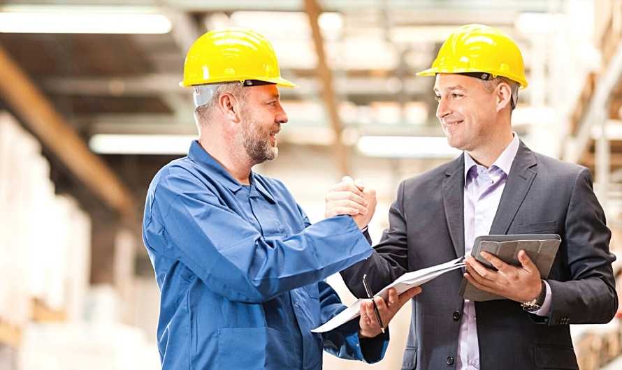 Picture of a businessman and architect wearing hard hats on a job site.