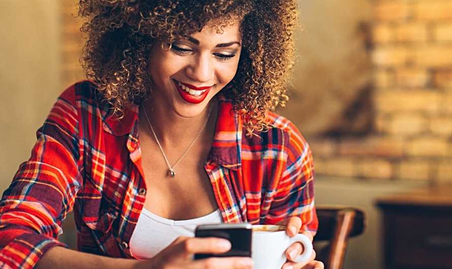A picture of a woman looking at a smart phone in a restaurant.